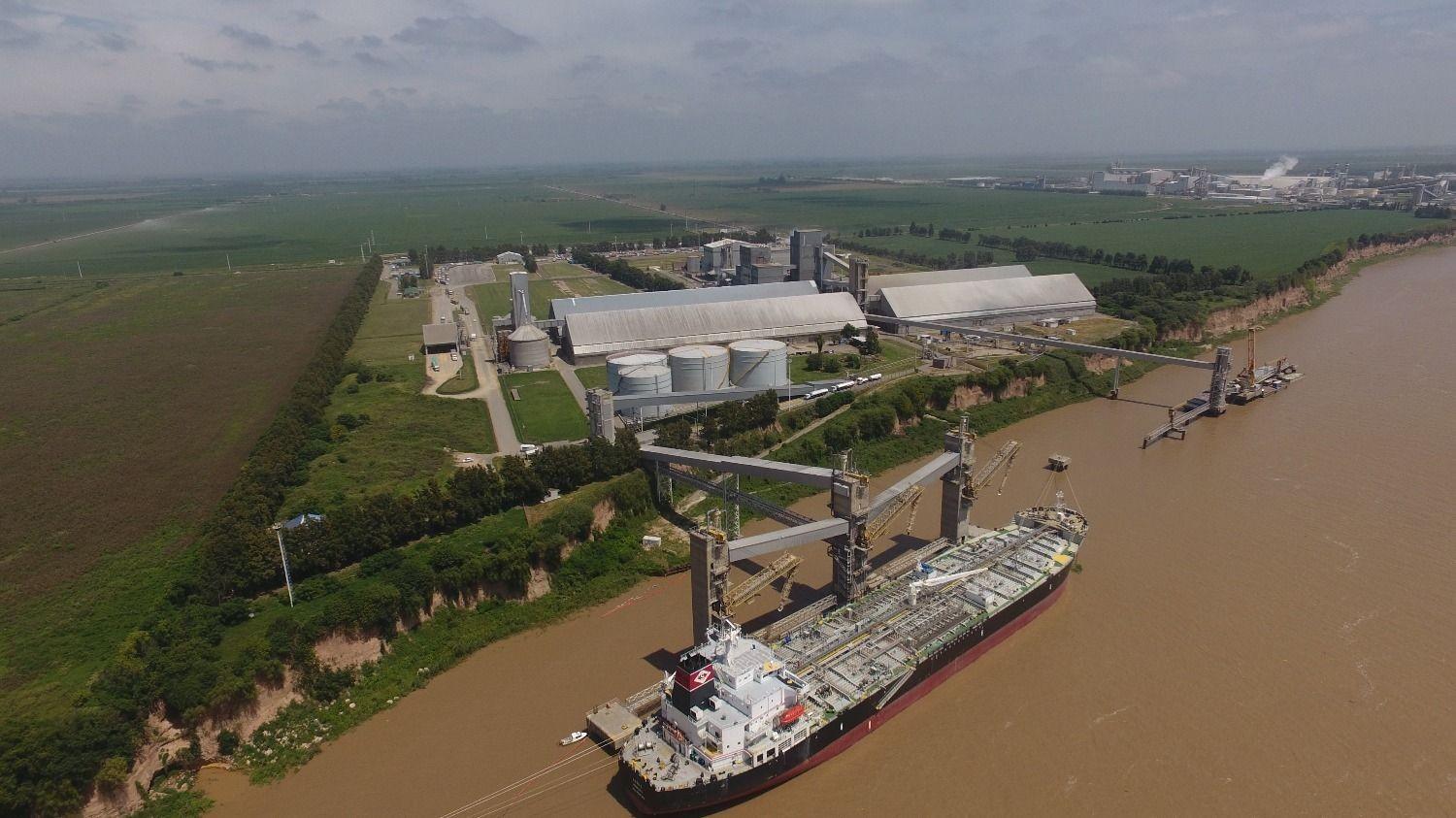 Vista aérea del complejo agroindustrial y portuario de Louis Dreyfus Company en Timbúes, con un buque amarrado sobre el río Paraná.