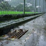 Agua de lluvia escurriendo hacia un drenaje vial